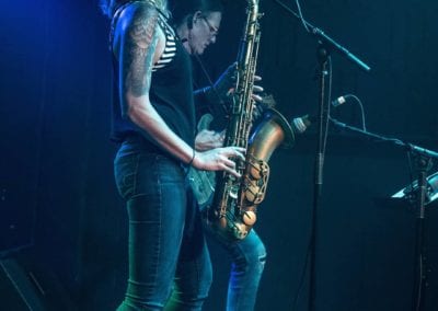 Tara playing a saxophone on stage