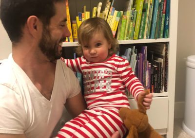 a man and his daughter in front of a bookshelf