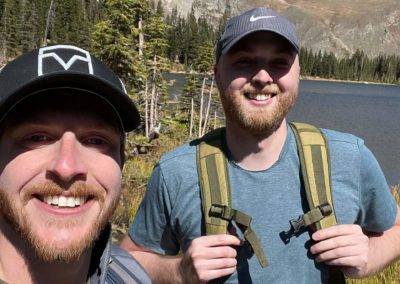 photo of two men at a mountain lake