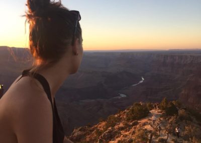 sunset photo of a woman looking into a canyon